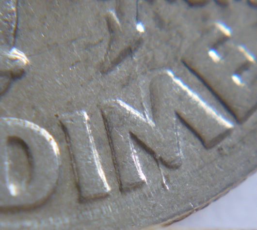 10 Cents USA-1997p-Coin désaligné-Coin fendillé a travers M de diMe-2.JPG